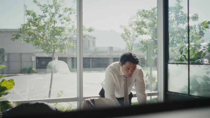 Man ending a call on his cell phone while in an office room