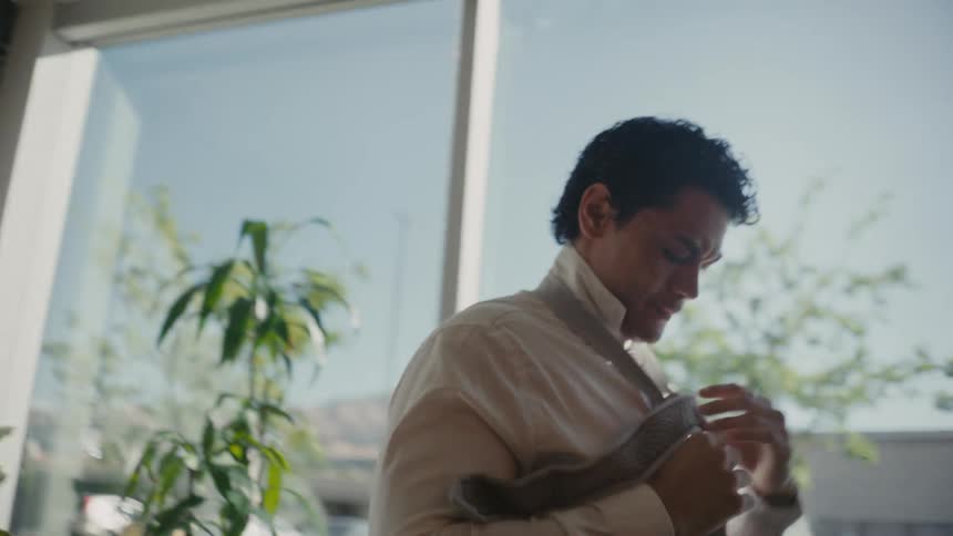 Man inside an office room adjusting his tie