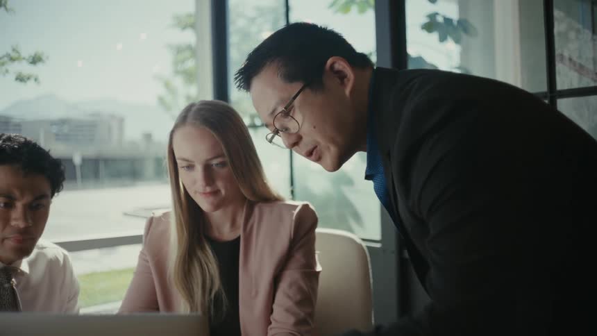 Two men and a woman gathered at an office table talking