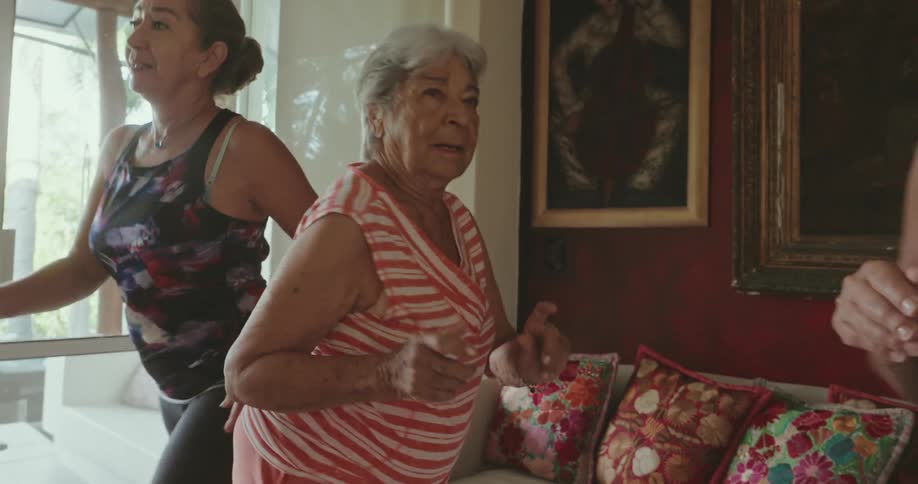 Three ladies dancing in the living room