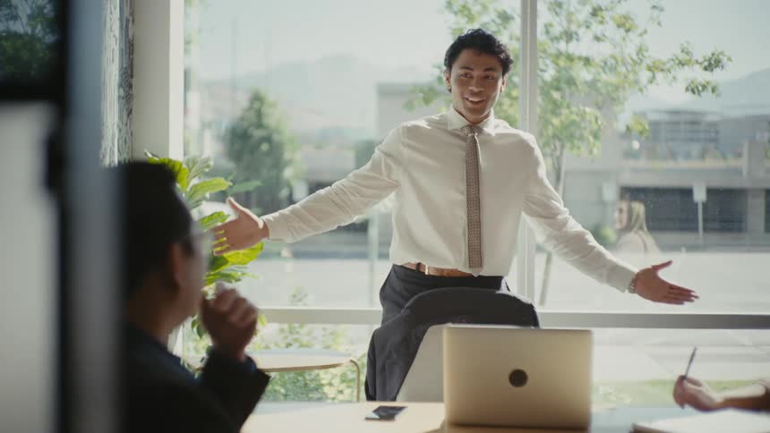 Man standing in an office room talking to two other people