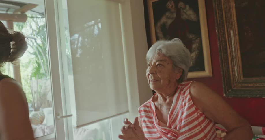 Lady dancing in the middle of two women in a living room
