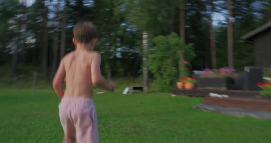 Boy playing soccer in the backyard with his grandfather