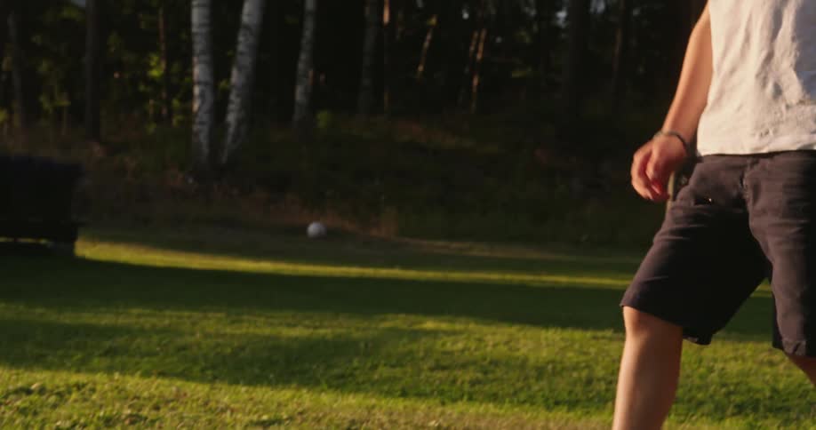 Boy placing the ball on the grass and preparing to kick