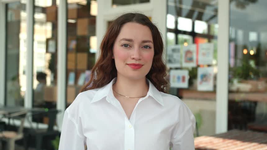A woman standing in front of a caf or restaurant setting