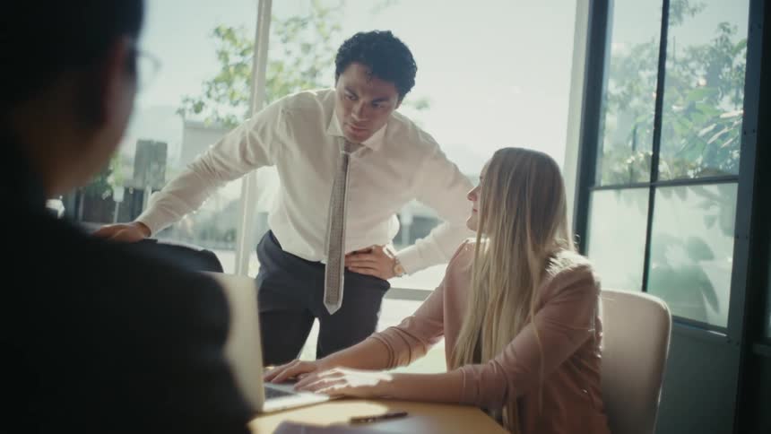 Three people in an office room talking