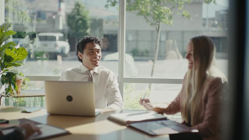 Coworkers hold a meeting at an office near a busy highway