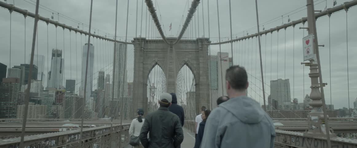 People are walking over a bridge in a city