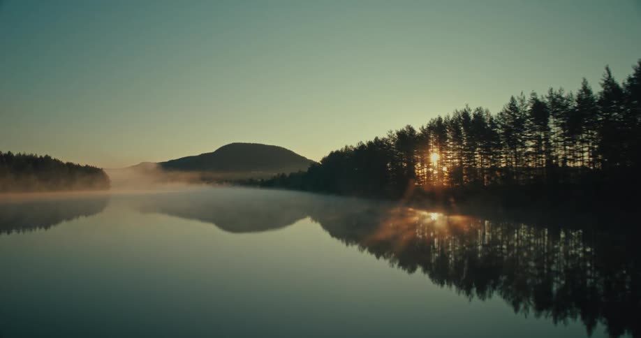 Haze covers the lake at sunrise