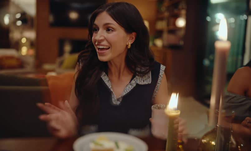 Woman talking at a house dinner party starts laughing
