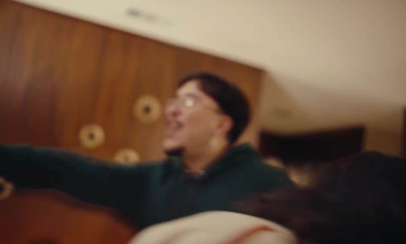 Man playing guitar and other people dancing in living room at a party