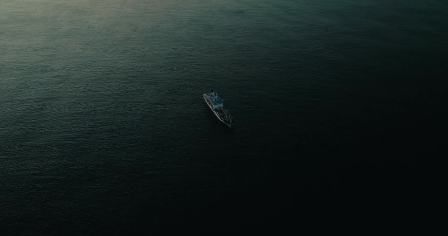 An aerial view of a vessel sailing in calm water