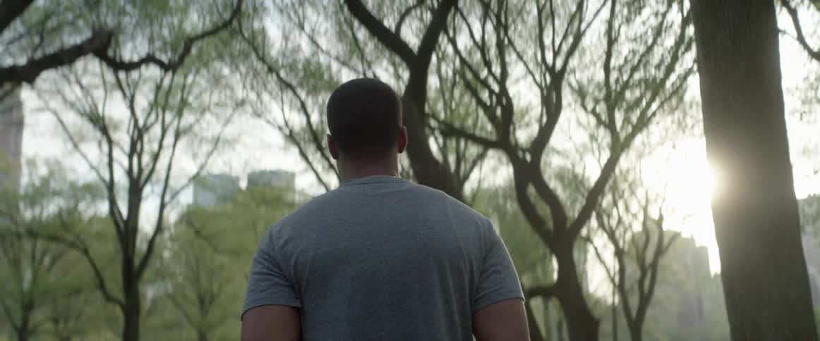Man looking out at the trees in the sunlight