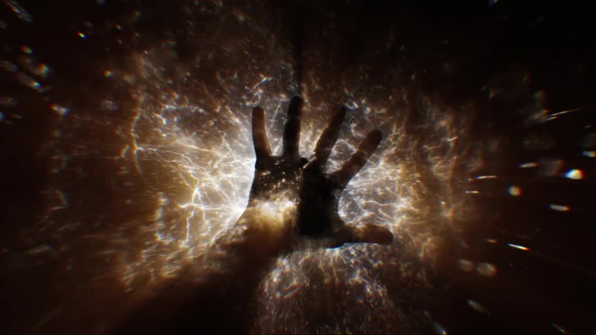 A single outstretched hand against a backdrop of an explosion of light and particles