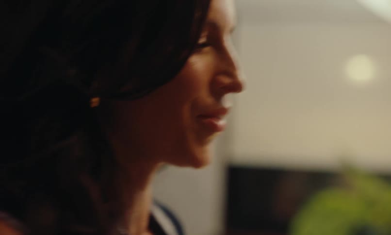 Side portrait of a woman talking in a cheerful indoor setting