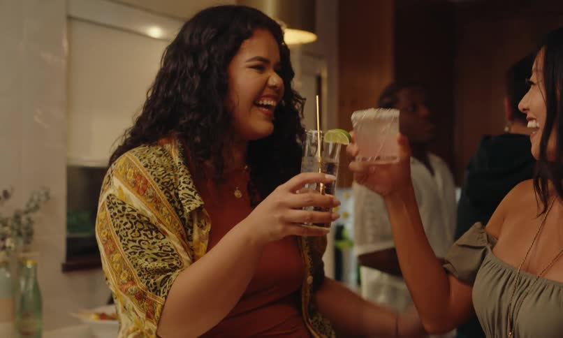 Two friends in the kitchen happily toasting at a party