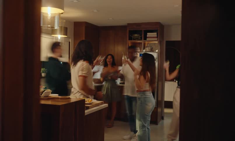 Friends have drinks in the kitchen at the party