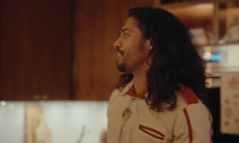 A group of friends greets each other in the kitchen of a fancy apartment