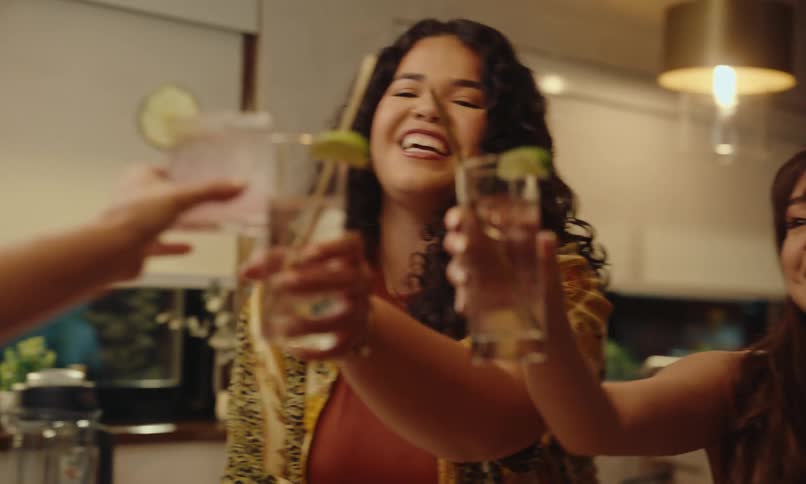 Friends in a kitchen toasting with drinks