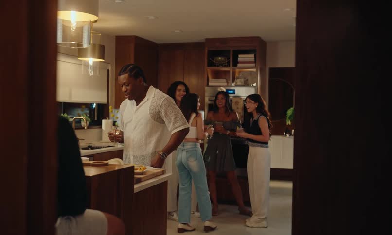 Group of friends in the kitchen eating drinking and talking to each other