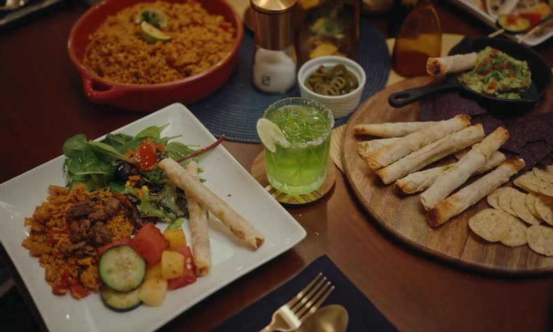 Table with plates of food and a hand pouring a drink