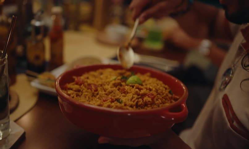 Group of friends at a celebration sitting at a table serving themselves food in bowls