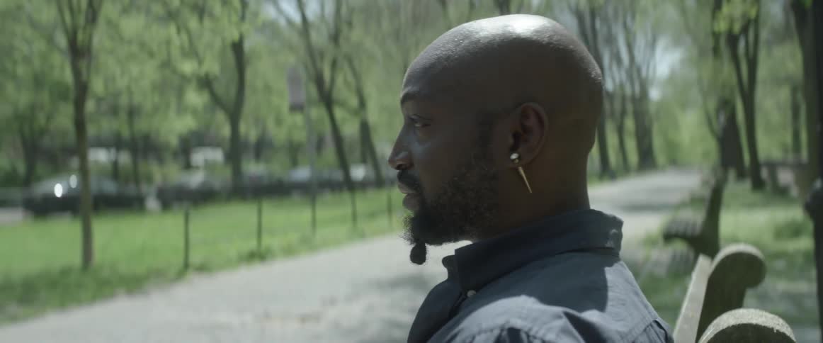 Man stands outside in a park on a sunny day