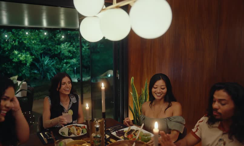 Man sitting at a table with four women talking at a dinner celebration in the evening