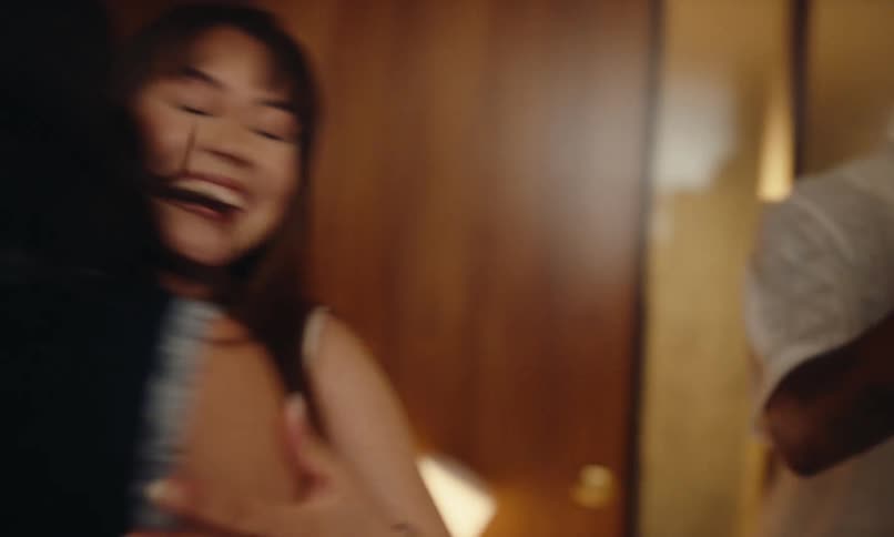 Couple of friends entering a house and greeting each other
