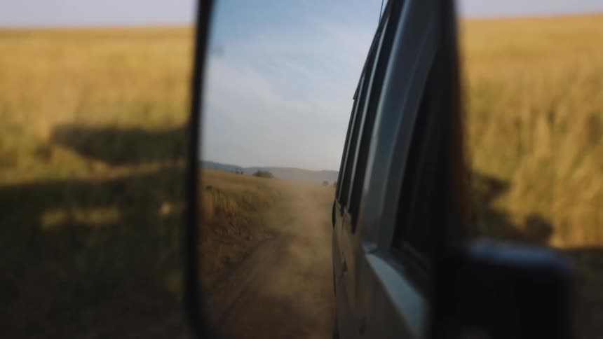 The mirror reflects the trail behind the vehicle