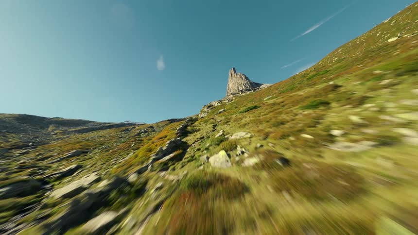 Aerial view of a valley with mountain hills and rocks in the background against a blue sky