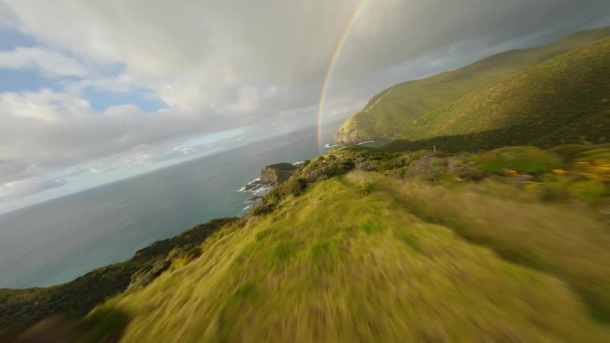 Landscape of a mountain valley with a sea in front and a rainbow