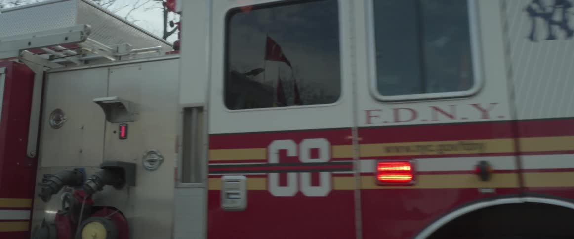 A fire truck drives through a New York street