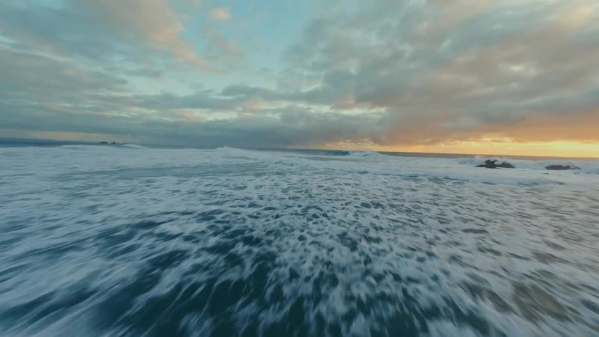 Sea landscape with waves and orange sky on the horizon
