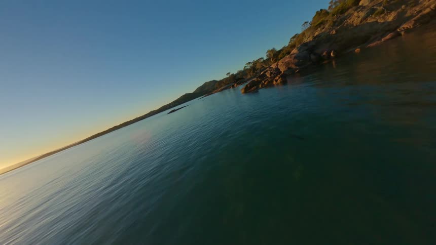 An aerial view of a coastal landscape during sunrise or sunset