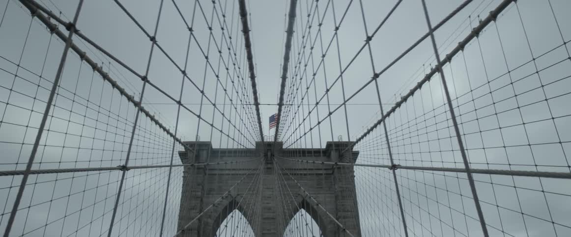 Cables and waving american flag on brooklyn bridge