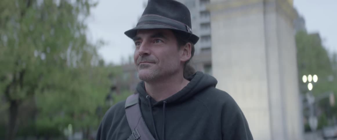 Man standing still and looking forward in a city