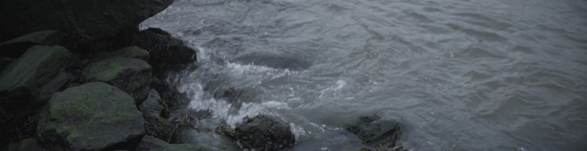 Waves are crashing along the beach rocks