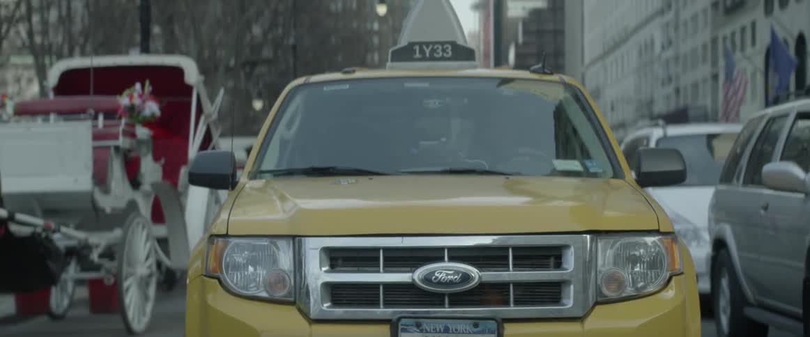 Yellow taxi sitting still in traffic in a large city