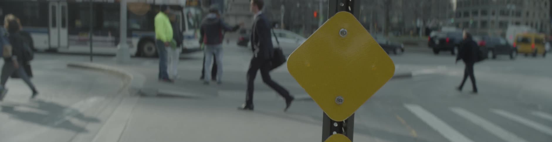A group of pedestrians walk through a city area