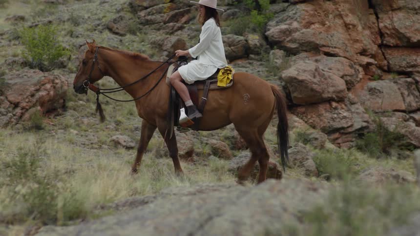 Man and woman in a mountain valley riding horses