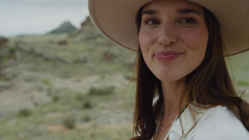 Portrait of a woman wearing a hat and taking pictures with a vintage camera