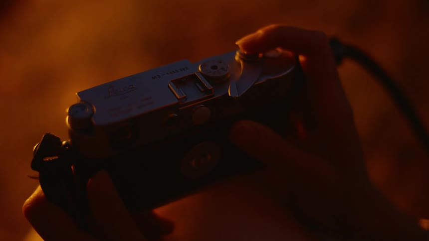 A persons hands moving a camera trigger and then placing it in front of their face to take a picture