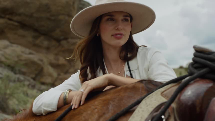 Cowgirl leaning on her arms and a horse