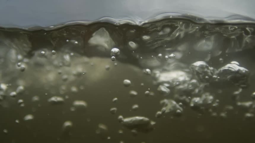 Extreme close up of flowing water with air bubbles