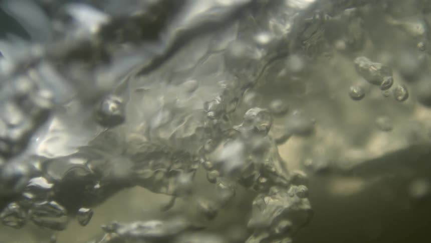 Extreme close up of a liquid with moving bubbles
