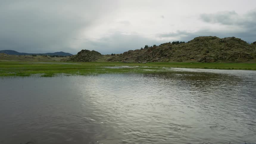 River flowing in a natural environment with rocky mountains in the background