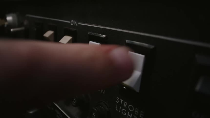 A finger puts two switches in the up position before they trip to the down position