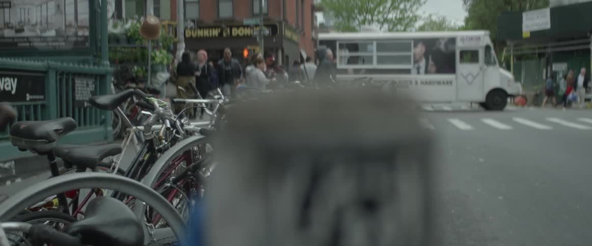 Bikes are parked by the sidewalk in this busy town