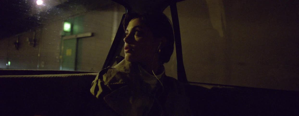 A woman is looking around the tunnel as she rides in the car